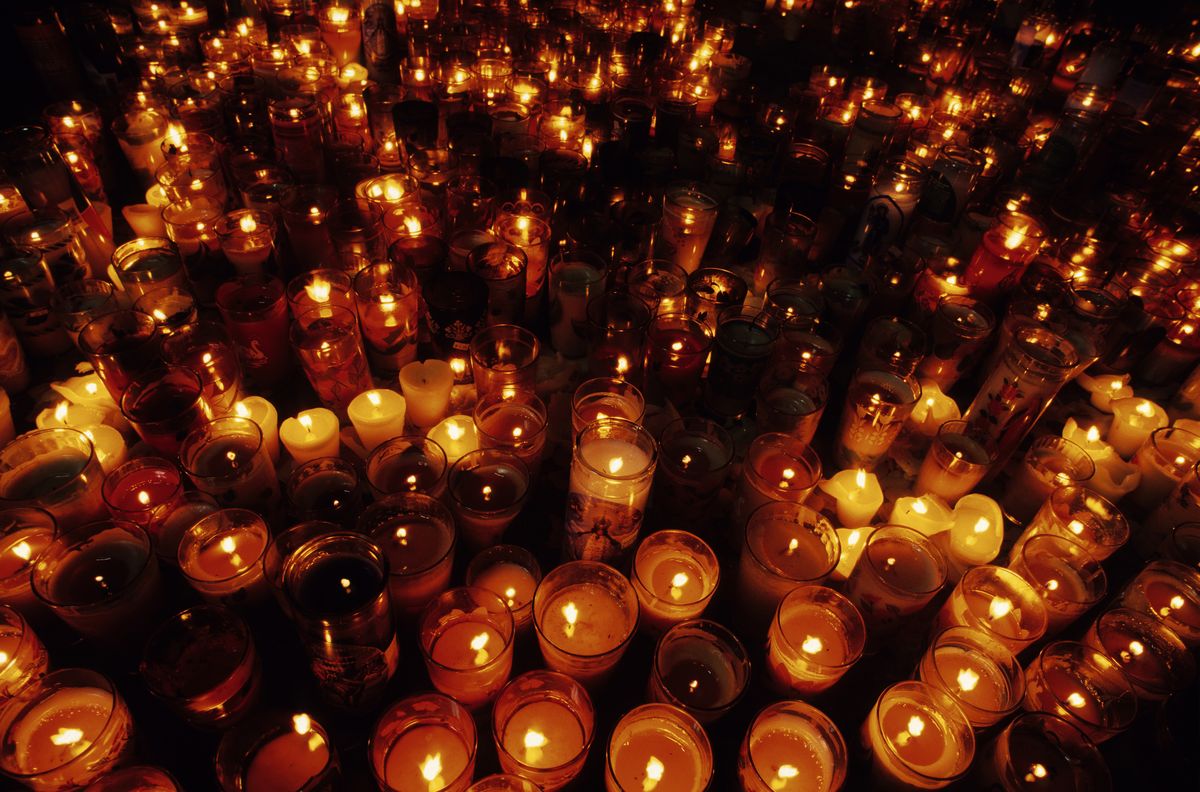 a close up of multiple candles in a vigil