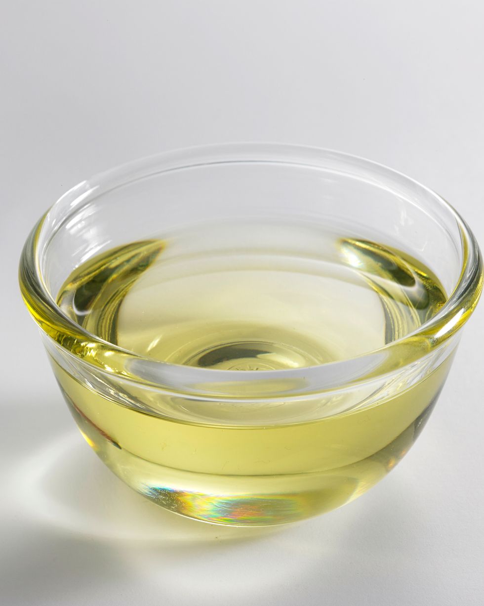 Close-Up Of Oil In Glass Bowl Against White Background