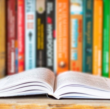 Close-up of opened book on bookshelf on blurred books background. Home library reading books concept close up of opened book on bookshelf on blurred books background home library reading books concept