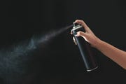 close up of person holding bottle against black background