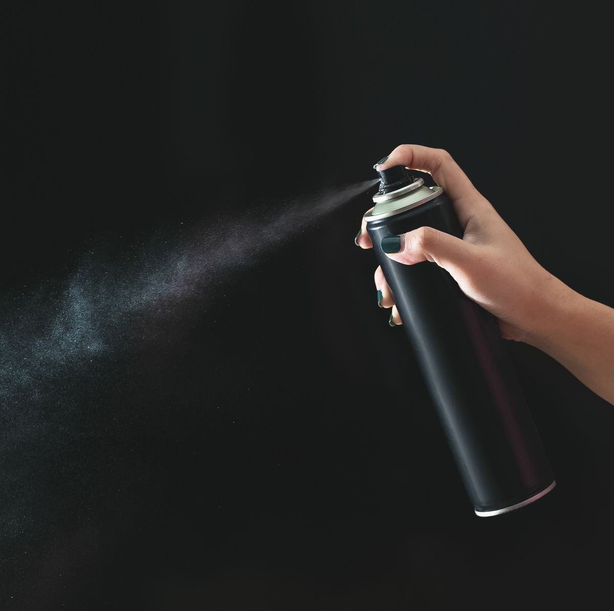 close up of person holding bottle against black background