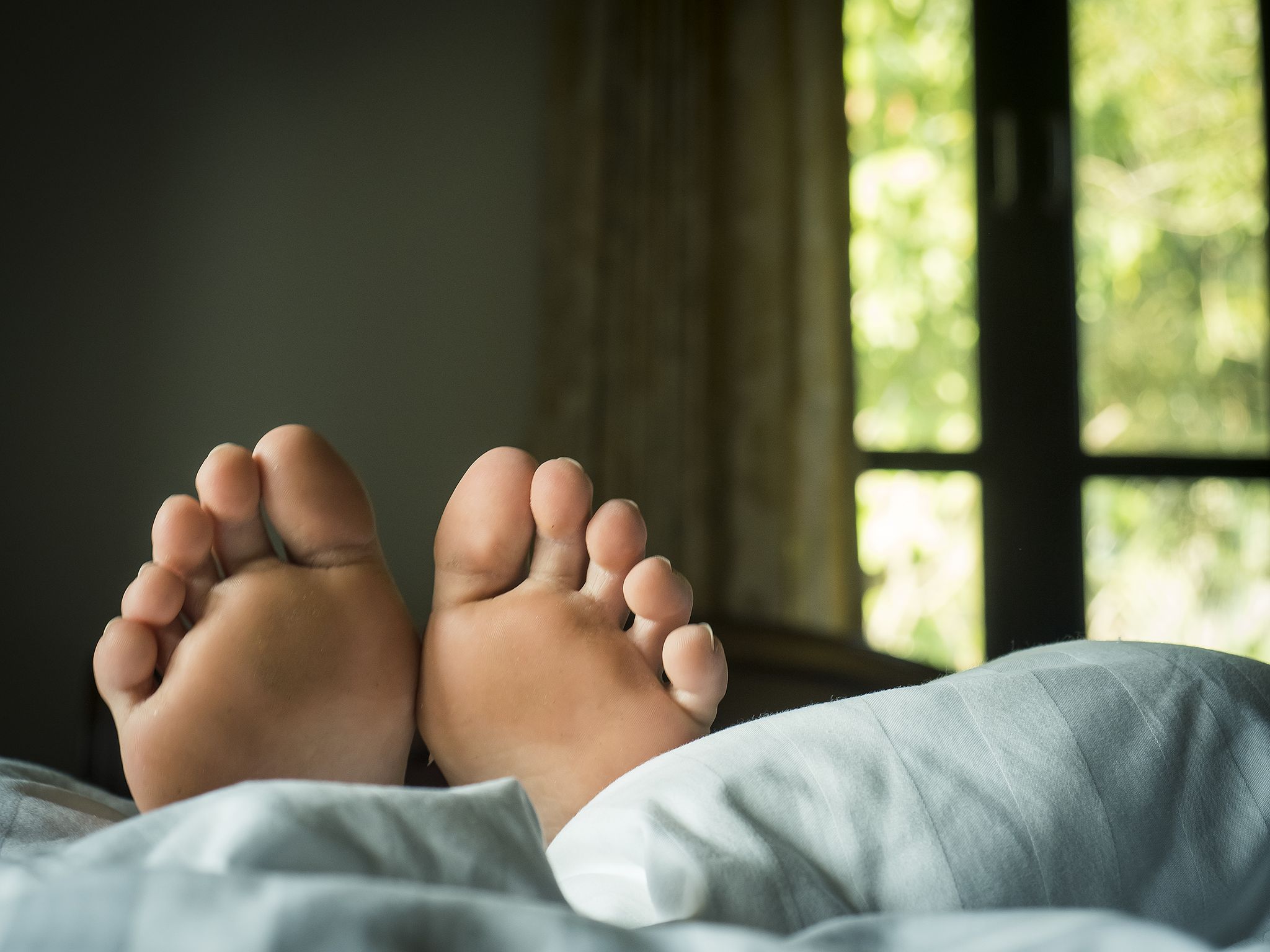 close up of person legs on bed at home