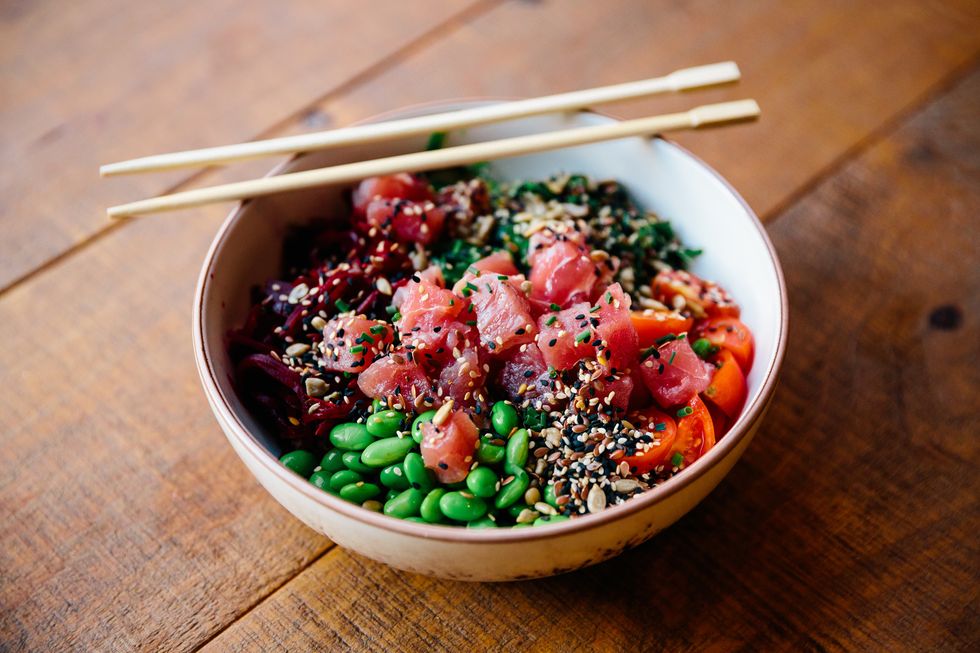 close
up of poke bowl with tuna, edamame beans and vegetables