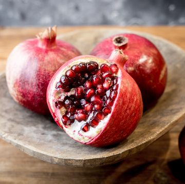 https://hips.hearstapps.com/hmg-prod/images/close-up-of-pomegranates-on-table-royalty-free-image-1701801291.jpg?crop=0.657xw:0.988xh;0.147xw,0&resize=360:*