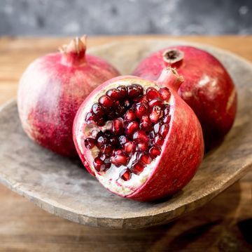 https://hips.hearstapps.com/hmg-prod/images/close-up-of-pomegranates-on-table-royalty-free-image-1701801291.jpg?crop=0.657xw:0.988xh;0.147xw,0&resize=360:*