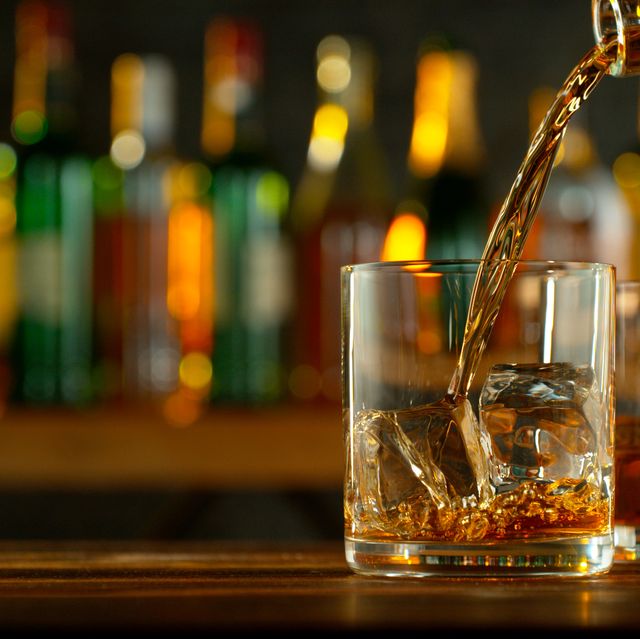 close up of pouring whiskey or rum on the bar
