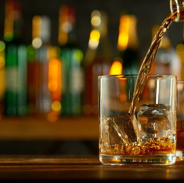 close up of pouring whiskey or rum on the bar