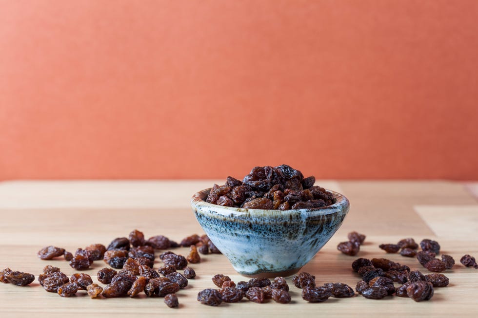 Close-Up Of Raisins On Wooden Table