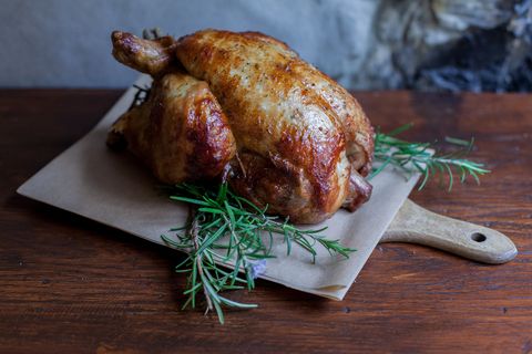 Close-Up Of Roasted Chicken On Cutting Board At Table
