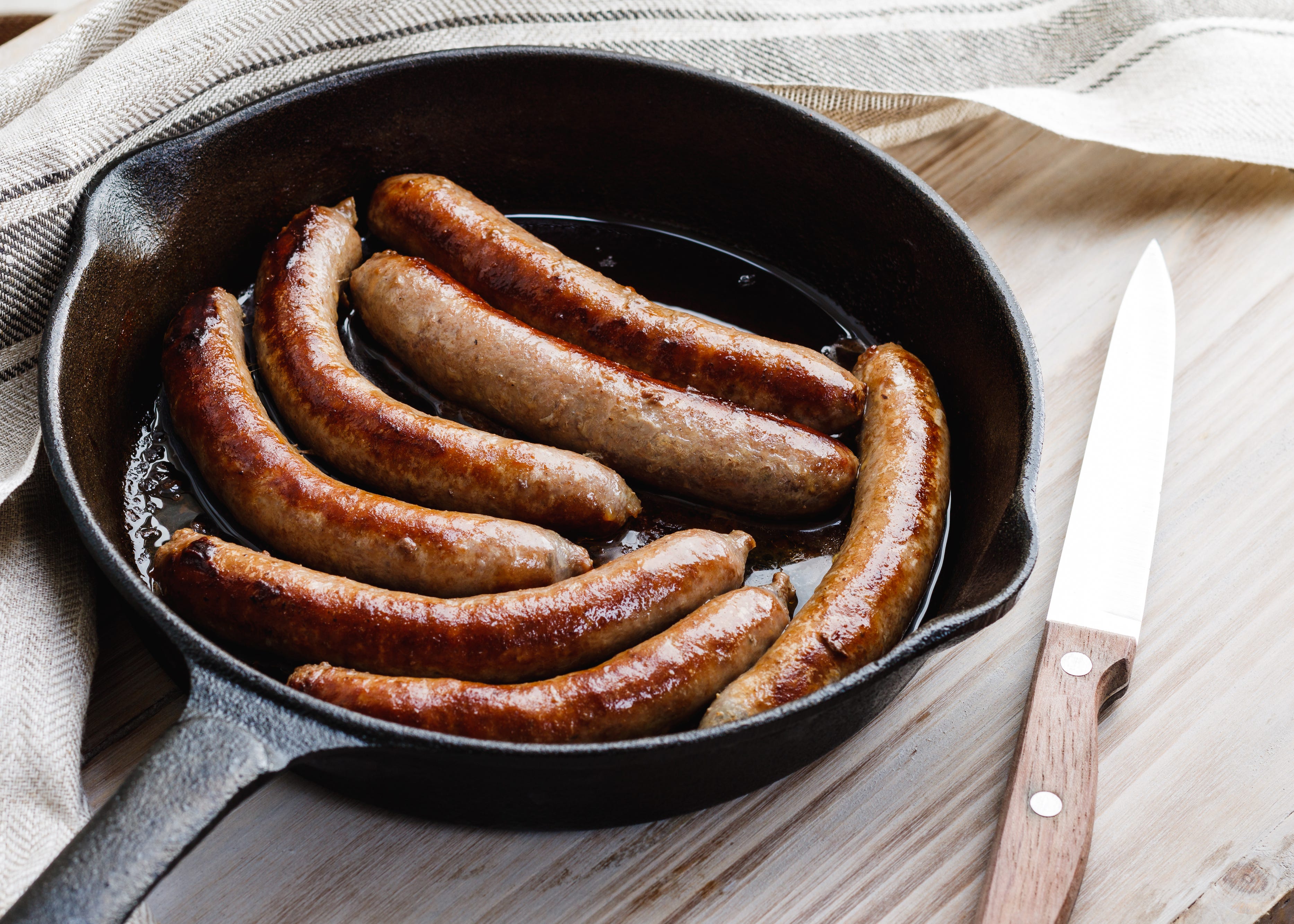 Close-Up Of Sausages In Frying Pan On Table
