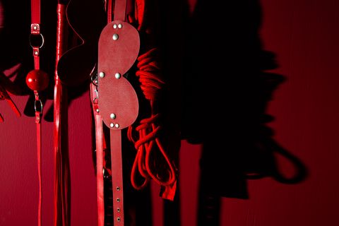 close up of sex toys hanging against wall