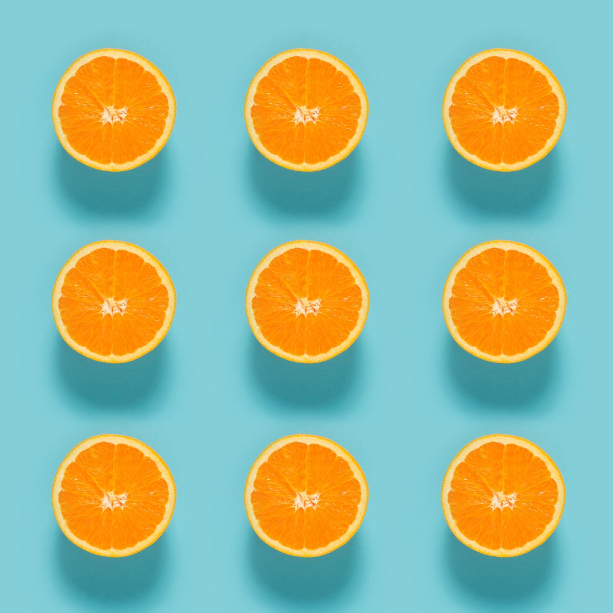 close up of sliced orange fruits on blue background