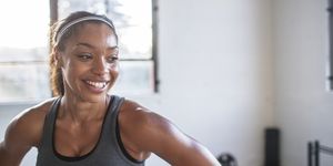 close up of smiling athlete looking away while standing in gym