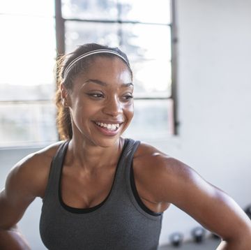 close up of smiling athlete looking away while standing in gym