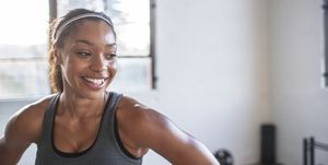 Close-up of smiling athlete looking away while standing in gym