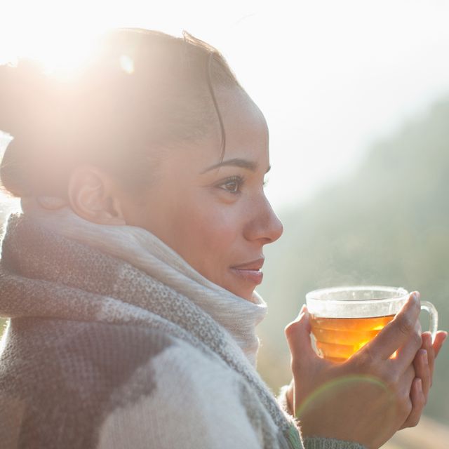close up of smiling woman drinking tea outdoors