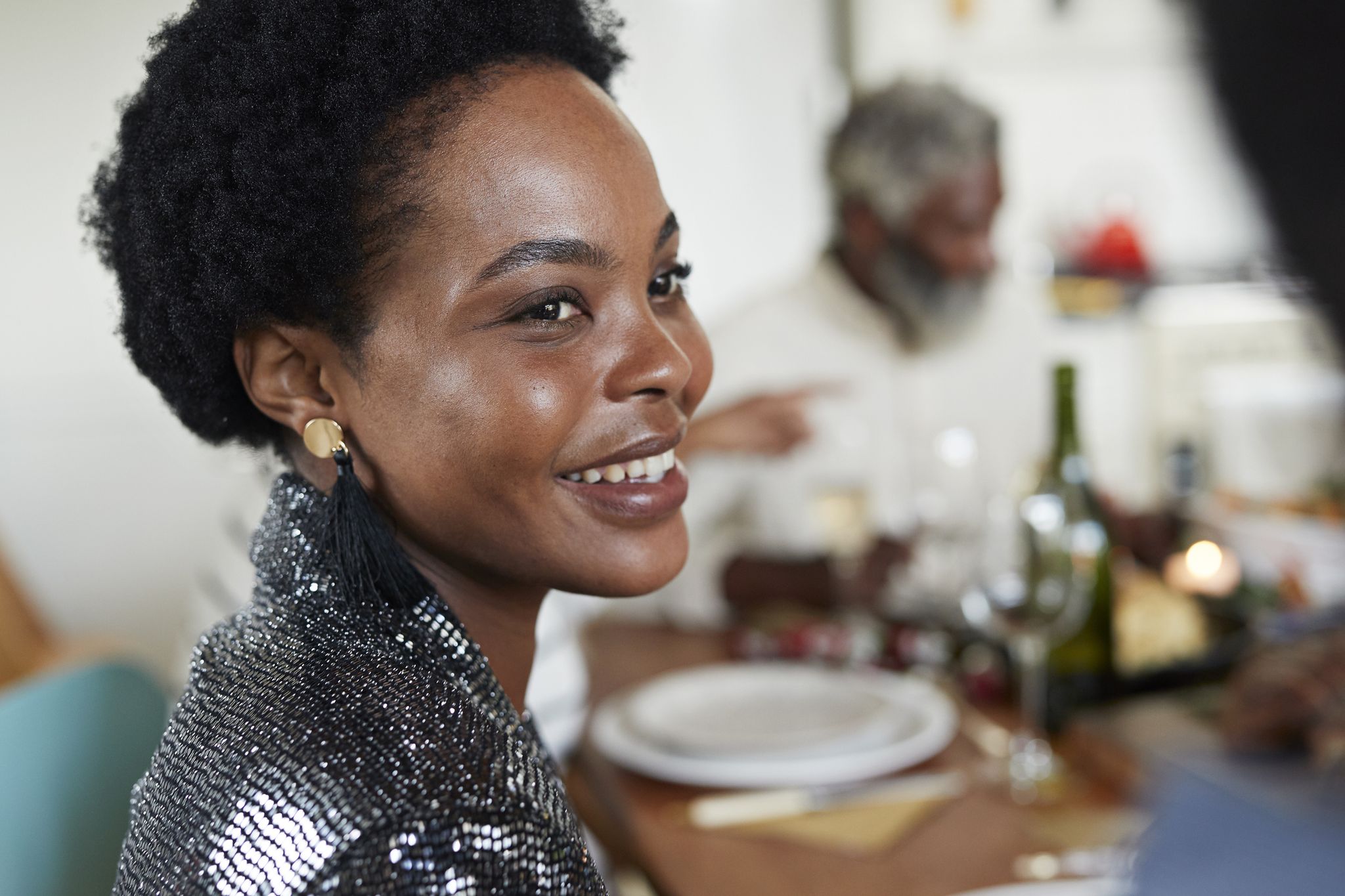 close up of smiling woman sitting at dining table