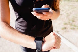 max heart rate close up of sporty young woman using cell phone and smartwatch