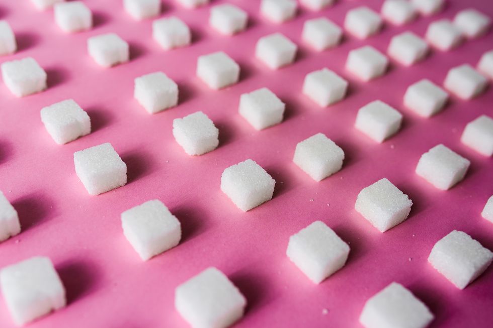 Close-Up Of Sugar Cubes Arranged On Pink Table