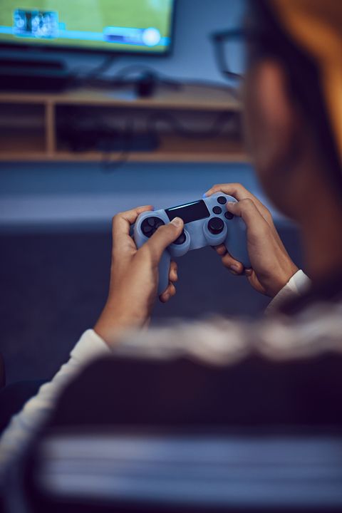 close up of person holding blue video game controller, giving up video games for lent