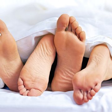 close up of the feet of a couple on the bed