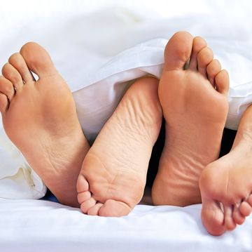 close up of the feet of a couple on the bed