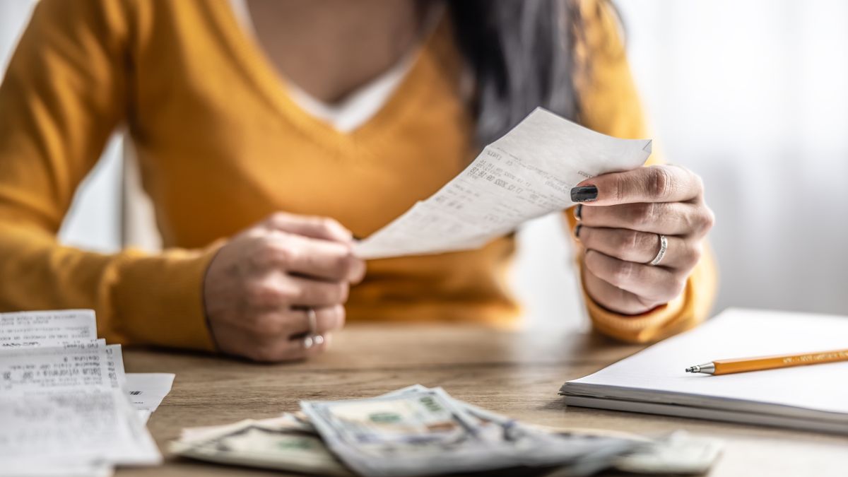close up of the hands of a young woman checking shopping receipts.
