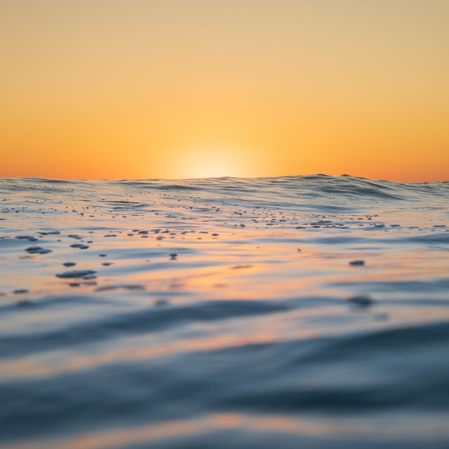 close up of the ocean surface as the sun starts to rise and  colour it golden