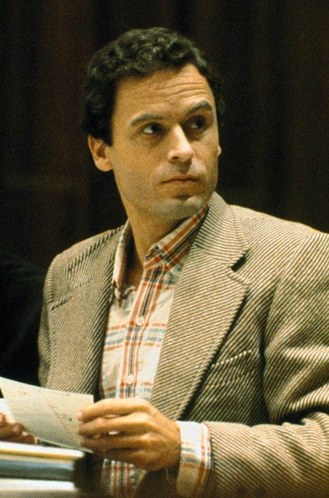 ted bundy holding notes and looking up to his left in a courtroom
