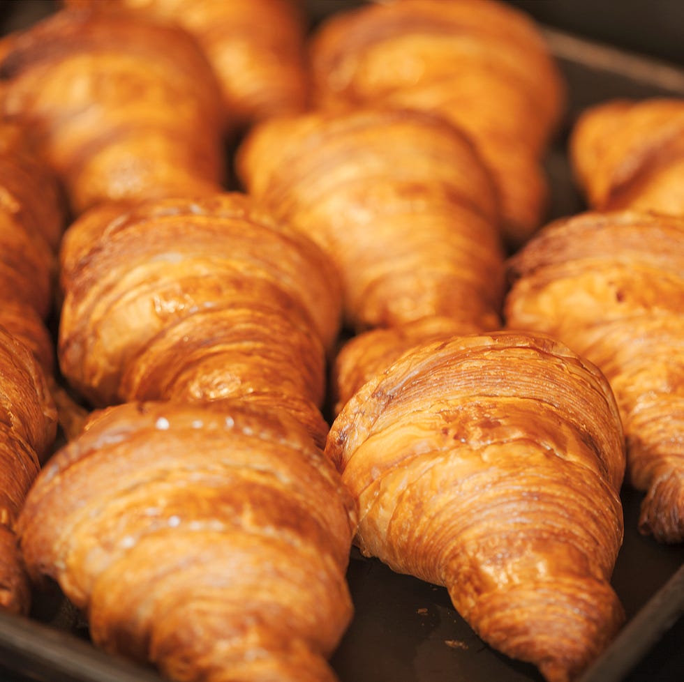 Close up of tray of freshly baked croissants in a bakery. close up of tray of freshly baked croissants in a bakery