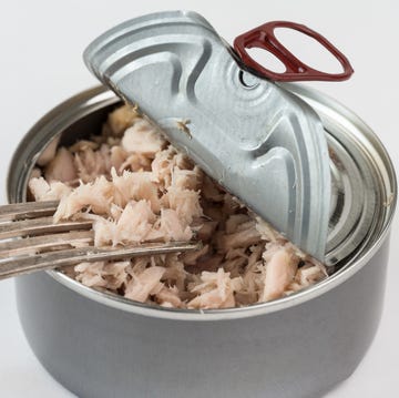 Close-Up Of Tuna In Container Against White Background Close-Up Of Tuna In Container Against White Background