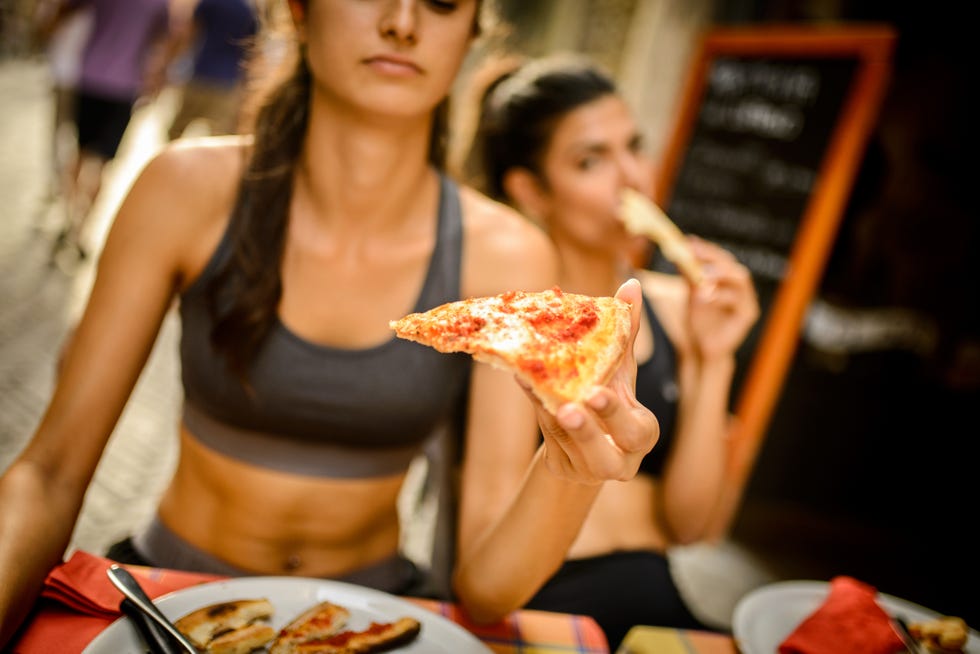 dos corredoras comiendo pizza