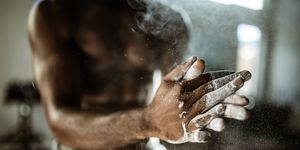 Close up of unrecognizable athlete preparing his hands with powder.