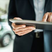 person using a tablet to refinance a car loan