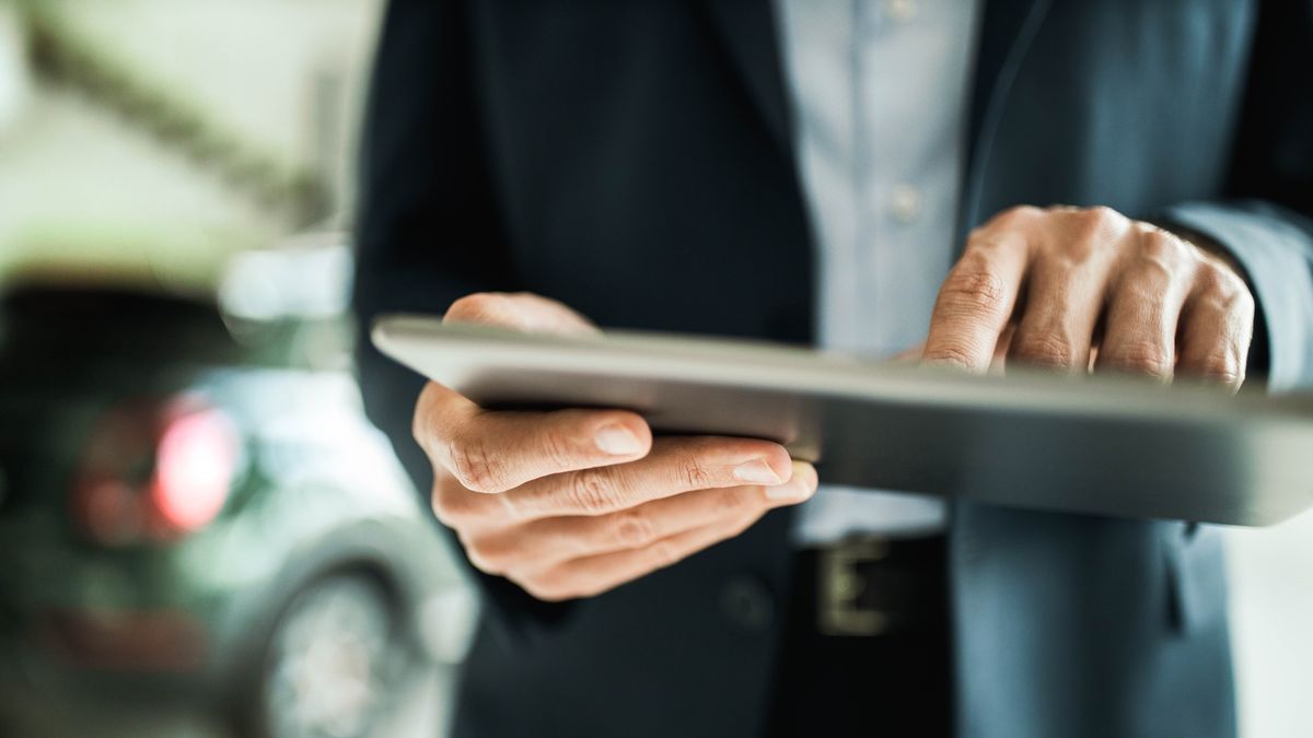 person using a tablet to refinance a car loan