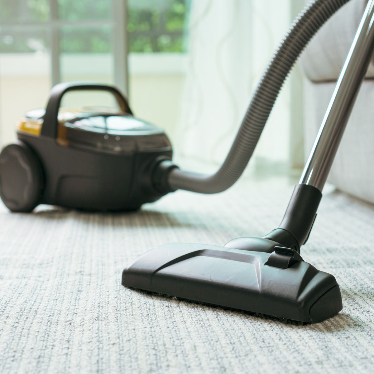 https://hips.hearstapps.com/hmg-prod/images/close-up-of-vacuum-cleaner-in-living-room-royalty-free-image-1617746688.?crop=0.668xw:1.00xh;0.135xw,0&resize=1200:*