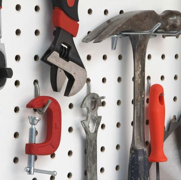 closeup of various tools hanging easy storage ideas to get your garage organized