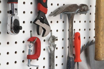 closeup of various tools hanging easy storage ideas to get your garage organized