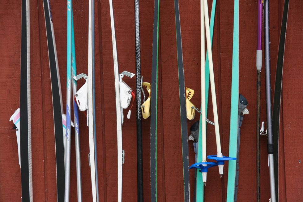 close up of cross country skis lined up against log cabin