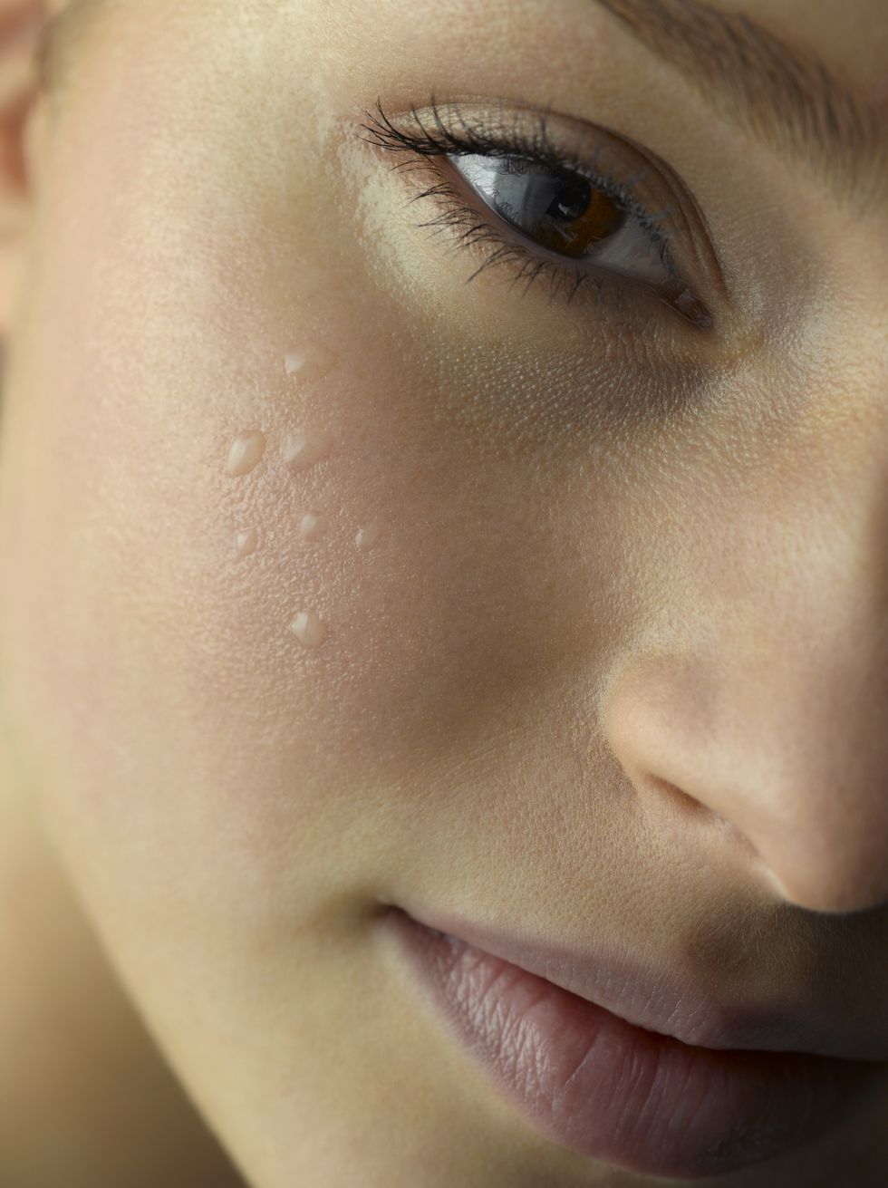 closeup of water droplets on young woman's cheek