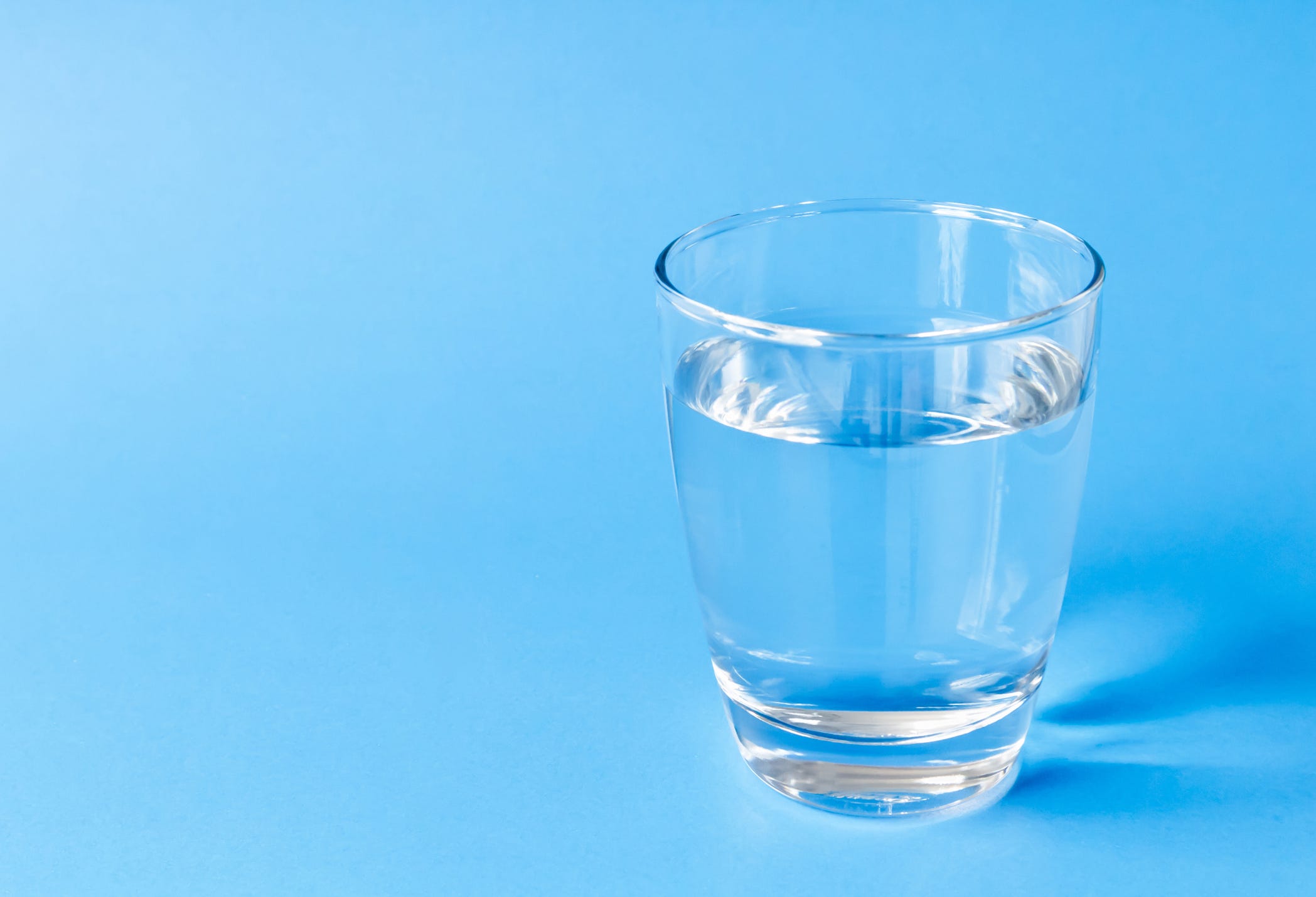 Close-Up Of Water In Drinking Glass Against Blue Background