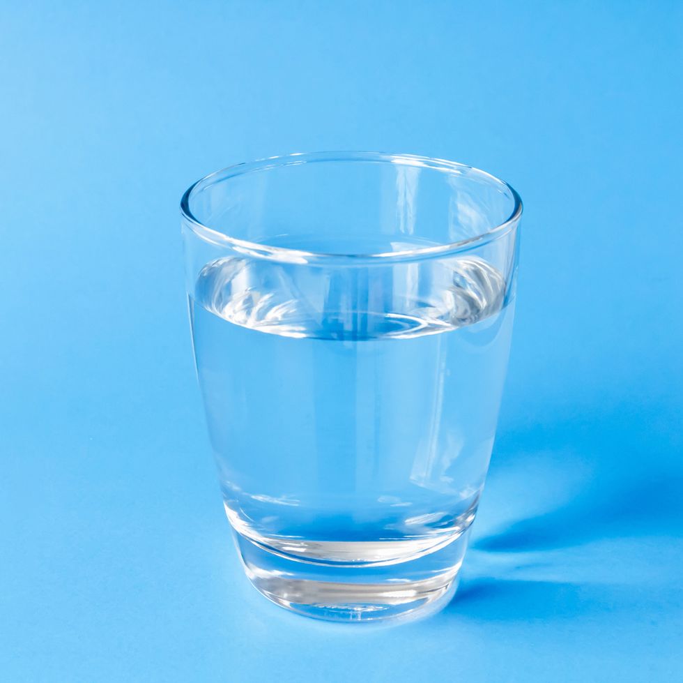 Close-Up Of Water In Drinking Glass Against Blue Background