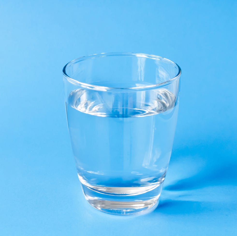 Close-Up Of Water In Drinking Glass Against Blue Background Close-Up Of Water In Drinking Glass Against Blue Background