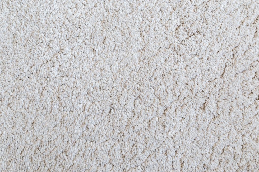 Close-up of white shaggy carpet texture background viewed from above.