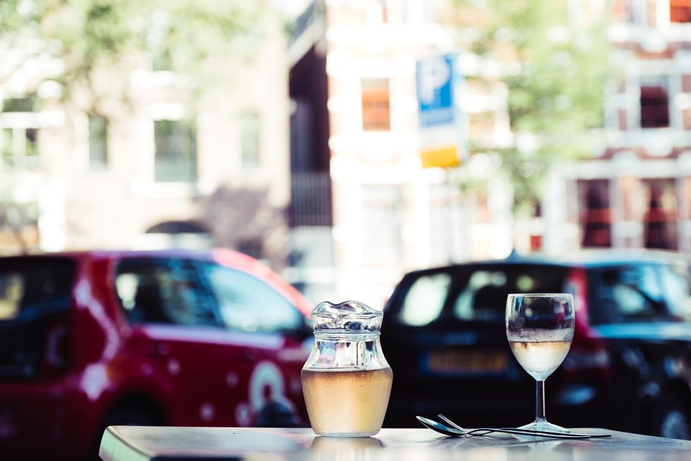 close up of wine glass on table against cars in city