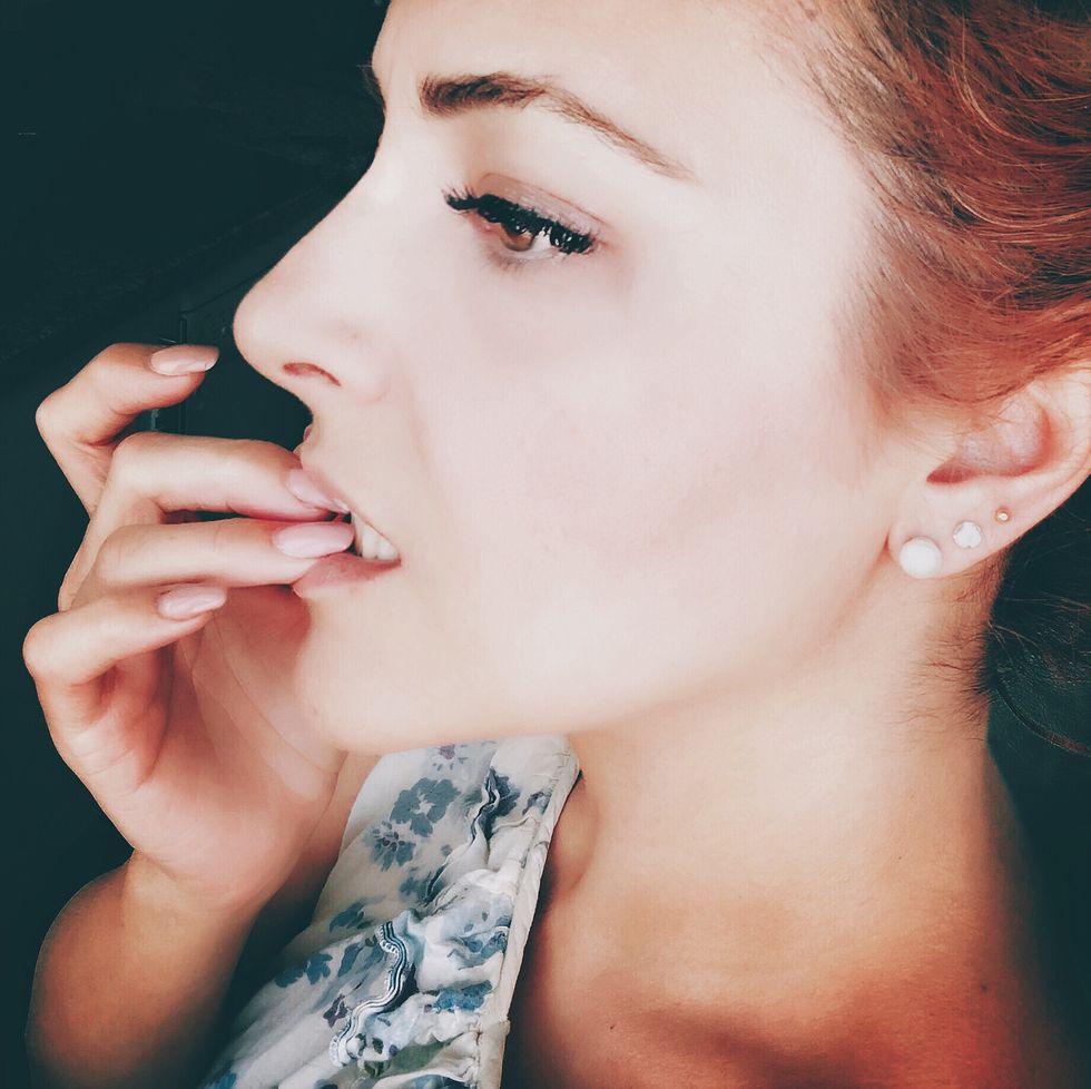 close up of woman biting nail