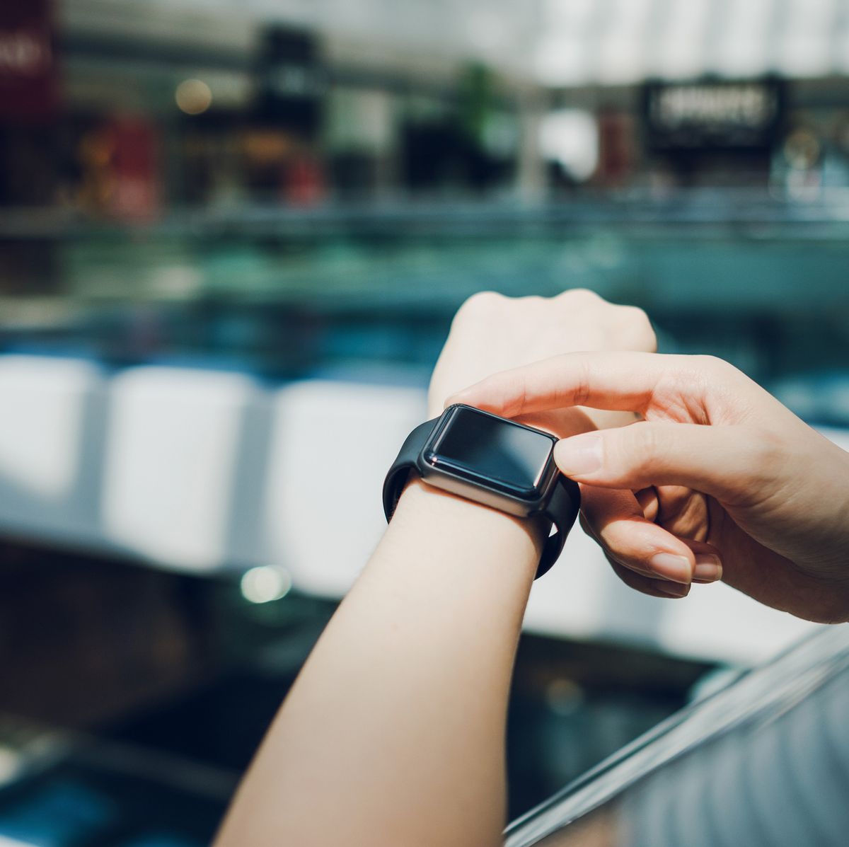 close up of woman checking the shopping list on smart watch in a shopping mall