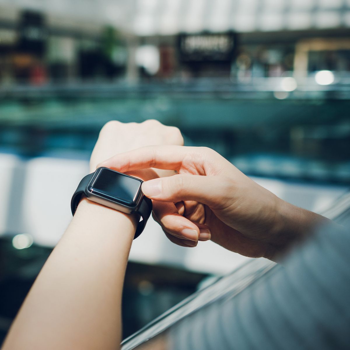 close up of woman checking the shopping list on smart watch in a shopping mall