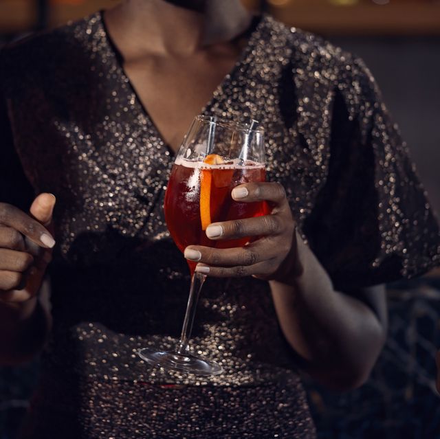 close up of woman holding a cocktail glass in a bar
