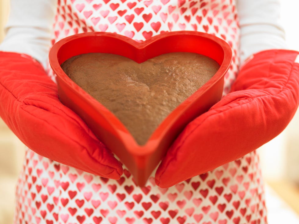 close up of woman holding heart shaped cake
